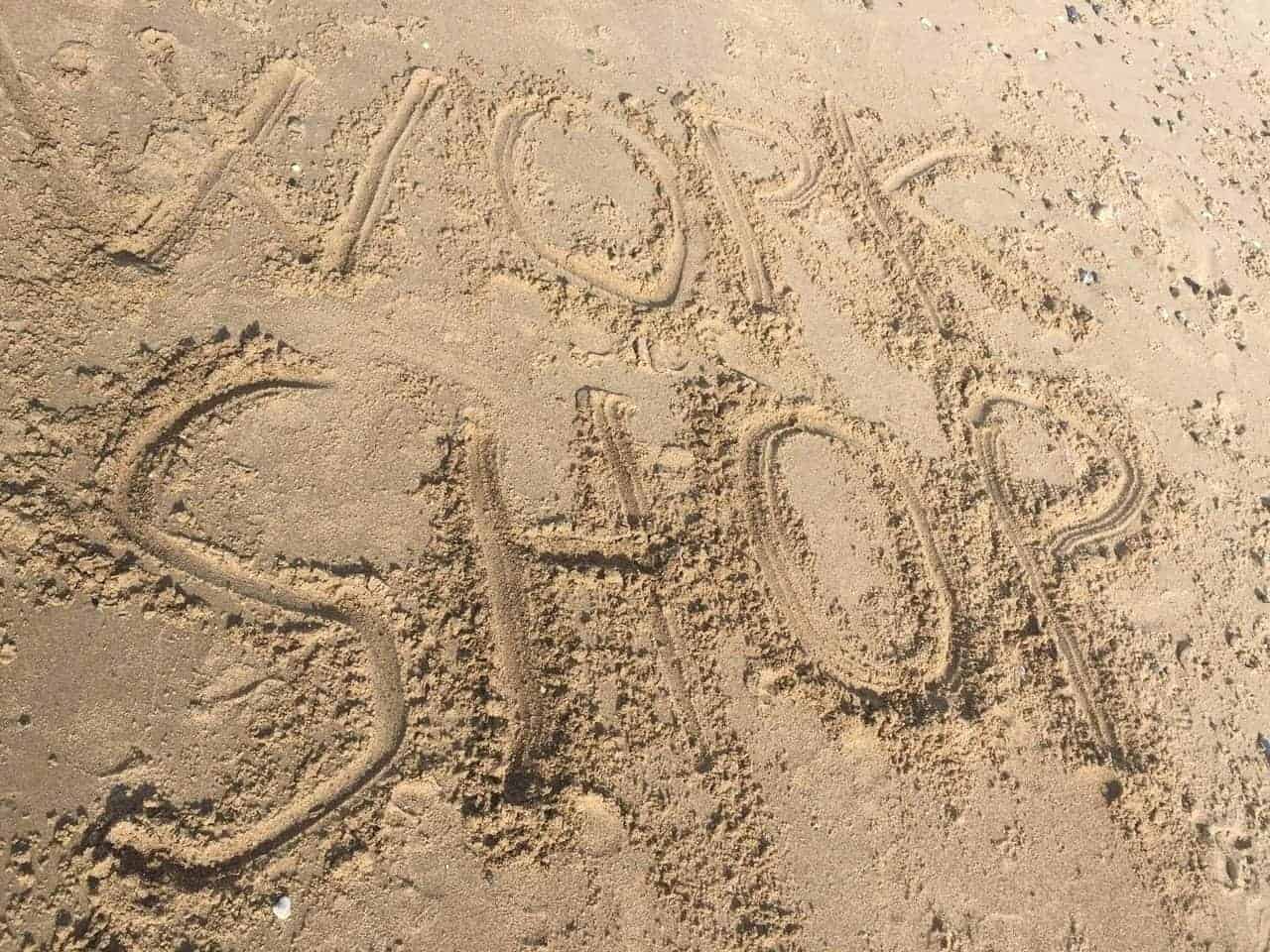 Workshop skrevet i sandet på en strand
