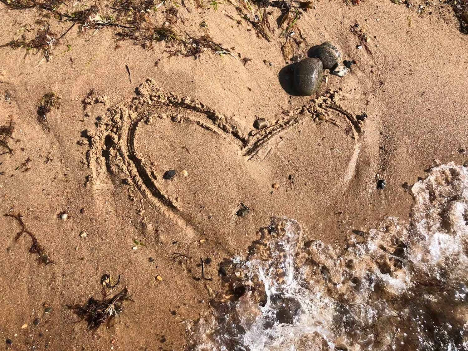 Hjerte tegnet i sandet på en strand
