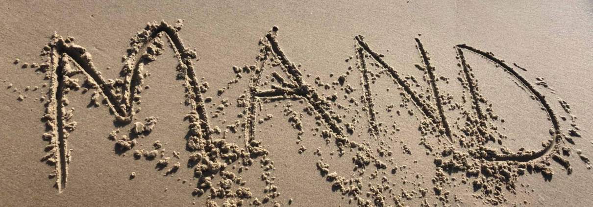 Mand skrevet i sandet på en strand